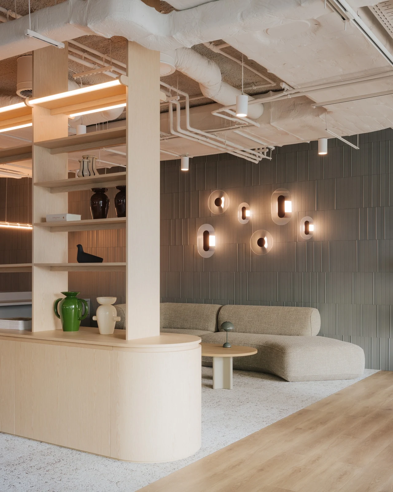 The fifth-floor reception: oak shelving, a curved sofa and sculpted wall lights